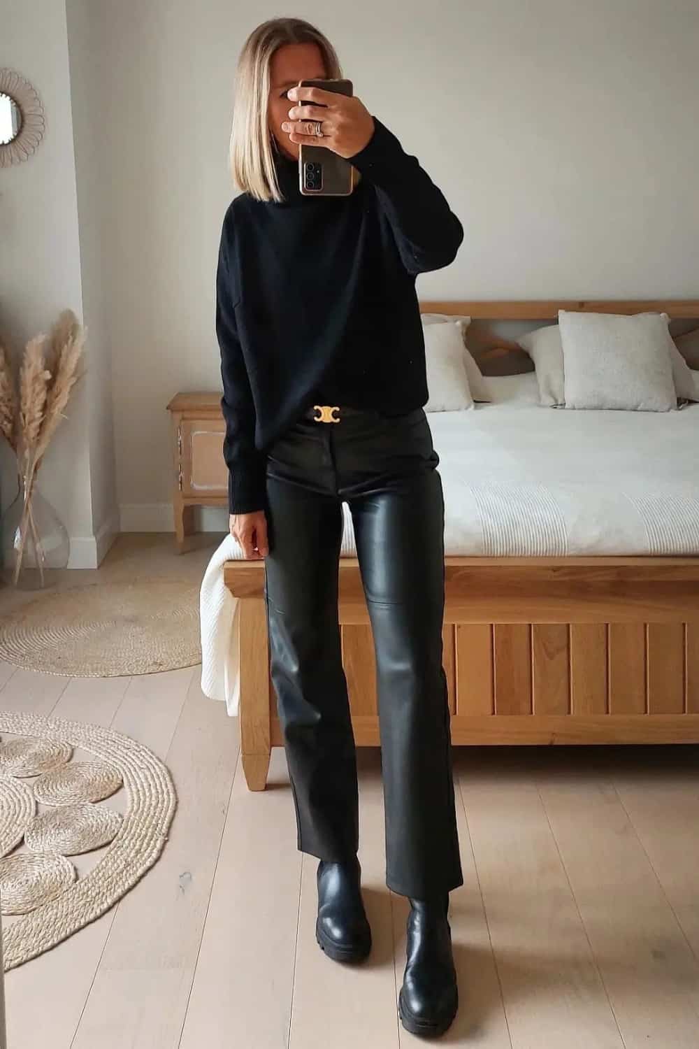 Leather pants outfit with black turtleneck, black and gold belt and black boots.