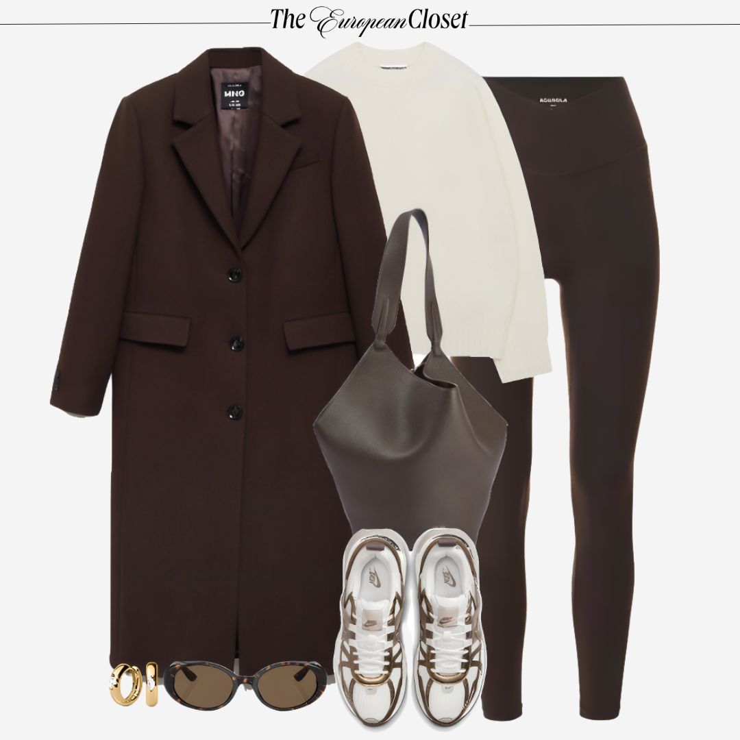 Flat lay of women's clothing and accessories, featuring a long brown coat, a cream sweater, brown leggings, white sneakers with gold accents, a brown tote bag, sunglasses, and gold hoop earrings, styled on a light background.