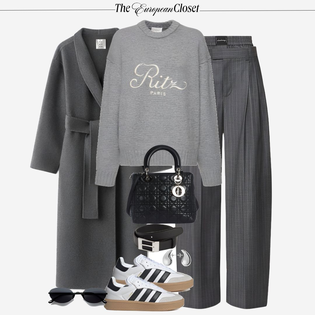 Flat lay of women's apparel and accessories, featuring a gray coat, a gray sweater with "Ritz Paris" text, gray trousers, Adidas sneakers, a black handbag, a belt, sunglasses, and headphones on a light background.